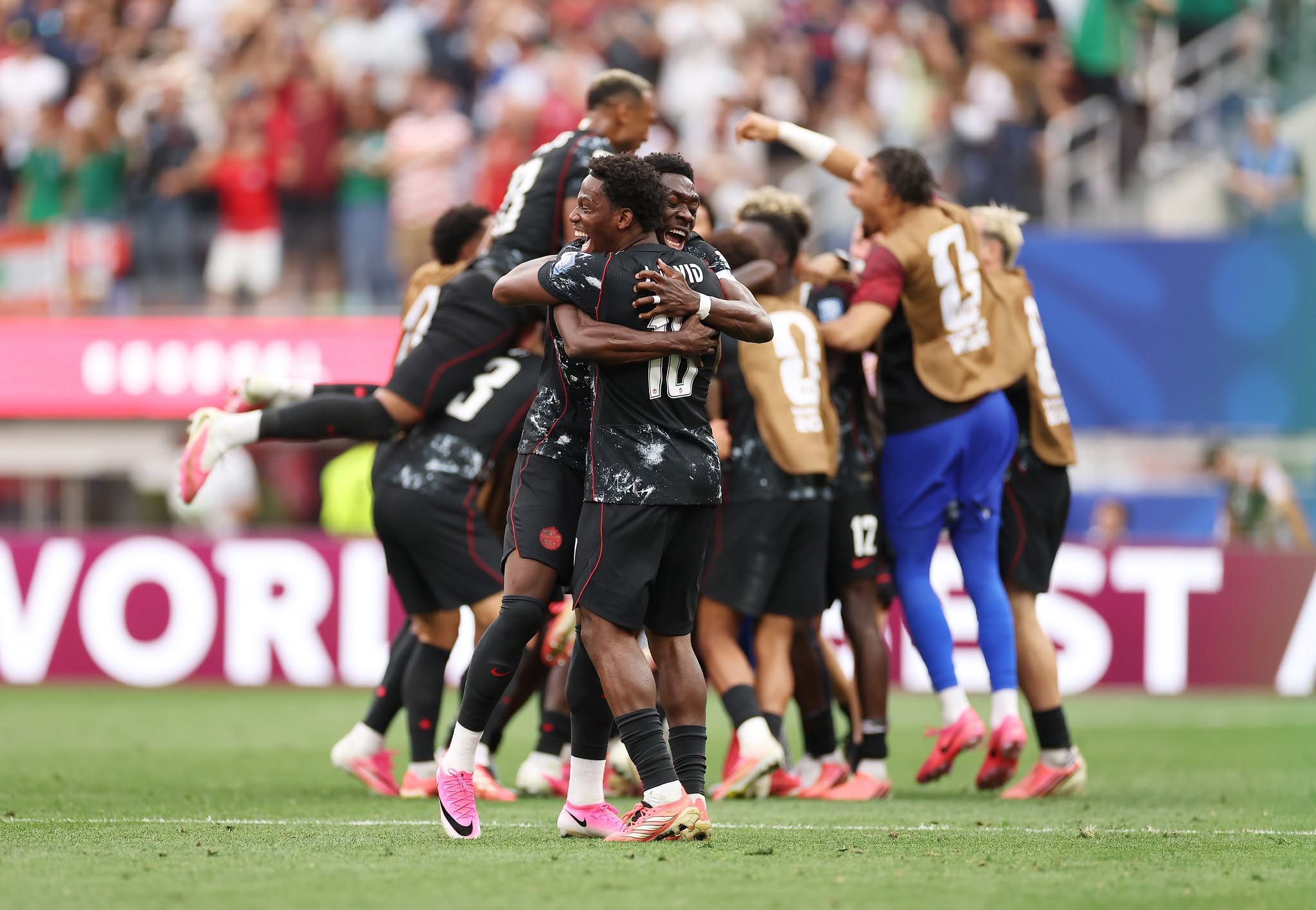 INGLEWOOD, CALIFORNIA - JUNE 28: Alphonso Davies #19 and Jonathan David #10 of Canada celebrate their side's first goal scored by Stephen Eustaquio #7 of Canada (not pictured) during the FIFA World Cup 2026 Round Of 32 match between South Africa and Canada at Los Angeles Stadium on June 28, 2026 in Inglewood, California. (Photo by Sarah Stier - FIFA/FIFA via Getty Images)